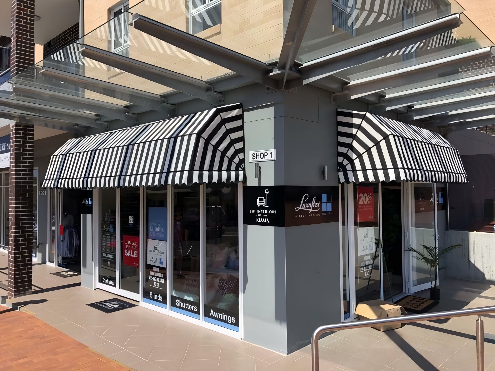 Storefront with black and white awning, glass windows, and gray accents.