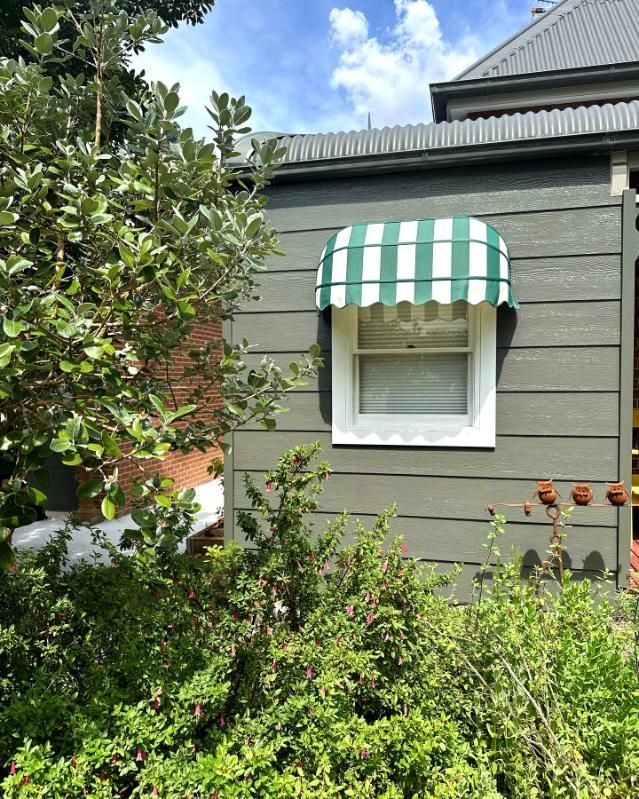 Window With Green And White Striped Awning — JSF Interiors Goulburn in Dapto, NSW