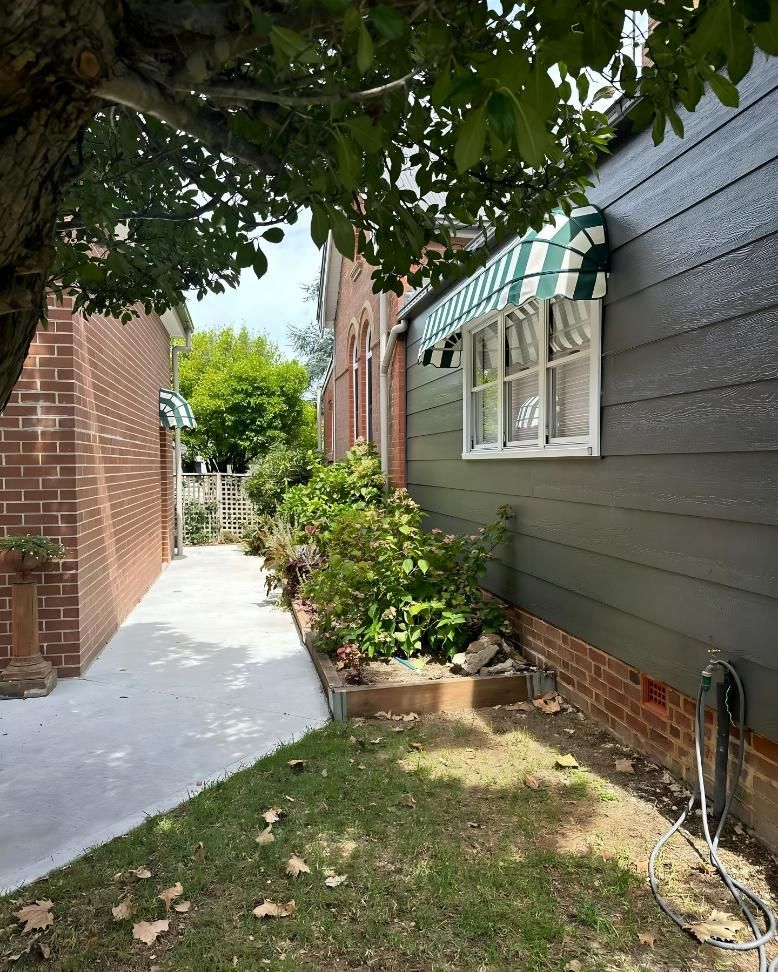 Sidewalk Between Brick Buildings And House With Green Awning — JSF Interiors Goulburn in Goulburn, NSW
