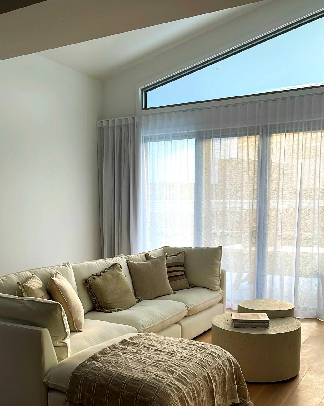 Living Room With Cream Sofa And Sheer Curtains — JSF Interiors Goulburn in Dapto, NSW