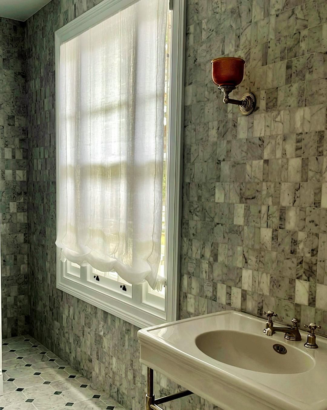 Bathroom With Marble Walls White Sink And Sheer Curtain — JSF Interiors Goulburn in Goulburn, NSW