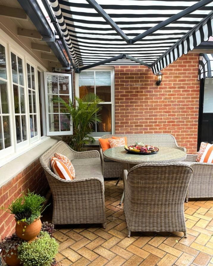 Patio With Wicker Furniture Under Striped Awning — JSF Interiors Goulburn in Berry, NSW
