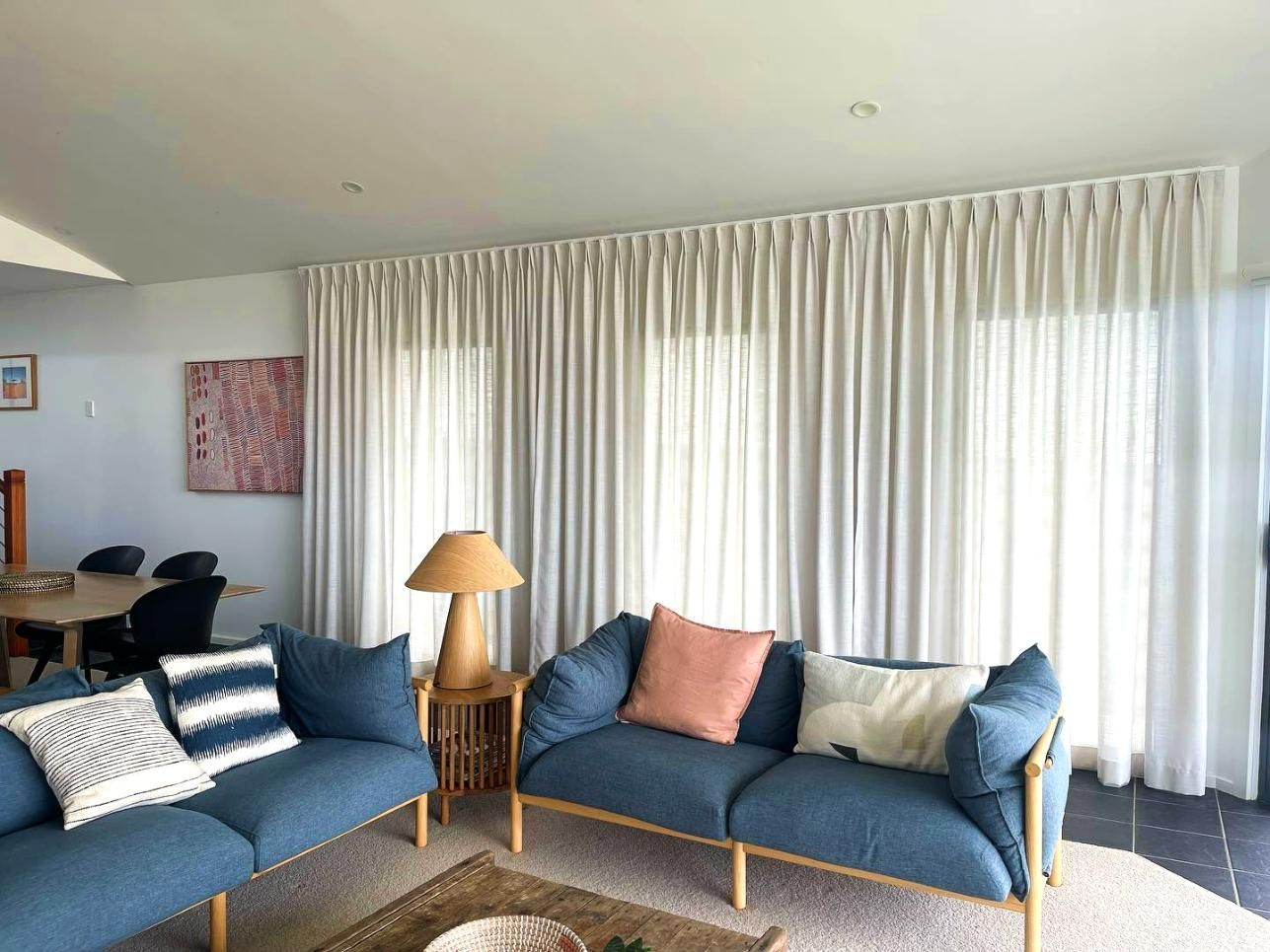 Living Room With Blue Sofas, Sheer Curtains, Wooden Table, And Lamp — JSF Interiors Goulburn in Gerringong, NSW