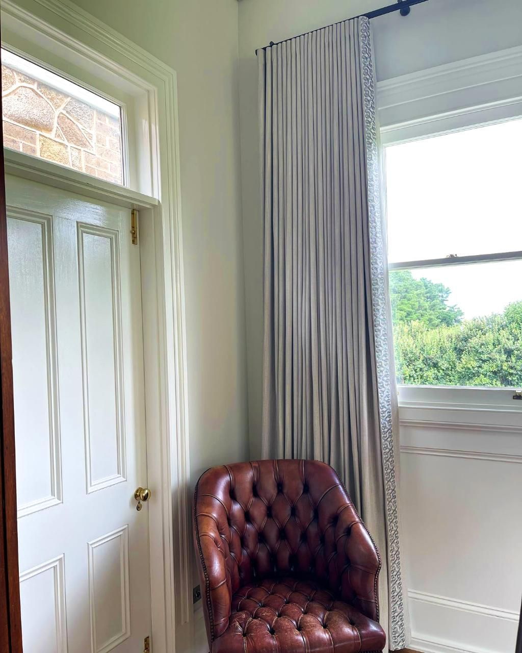 Brown Leather Armchair By Window With Light Grey Curtains — JSF Interiors Goulburn in Bowral, NSW