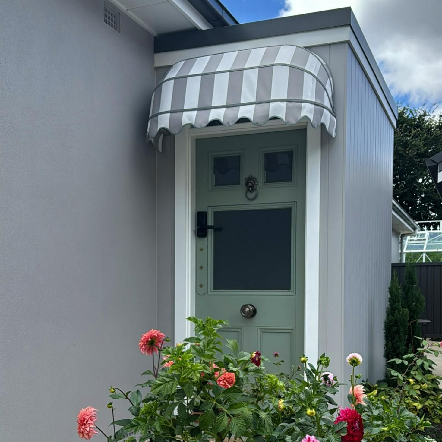 Light Green Door With Awning And Colorful Flowers — JSF Interiors Goulburn in Goulburn, NSW