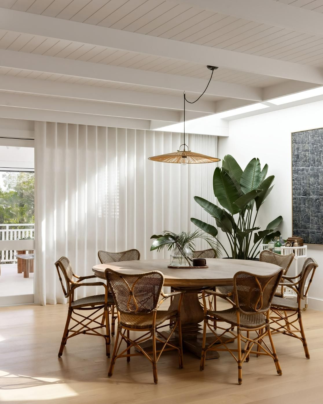 Dining Room With Round Wooden Table And Rattan Chairs — JSF Interiors Goulburn in Goulburn, NSW