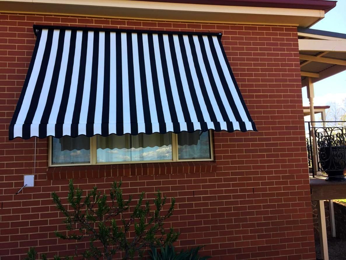 Black And White Striped Awning Over Window On Brick Building — JSF Interiors Goulburn in Mittagong, NSW