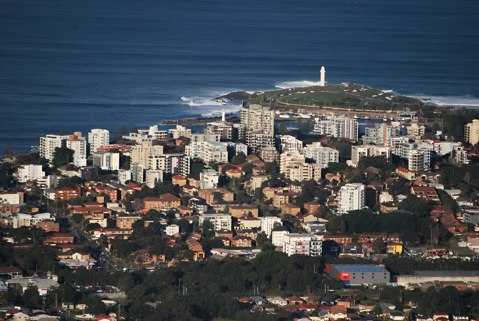 Coastal City View With Lighthouse Turquoise Ocean And Sandy Beach — JSF Interiors Goulburn in Wollongong, NSW
