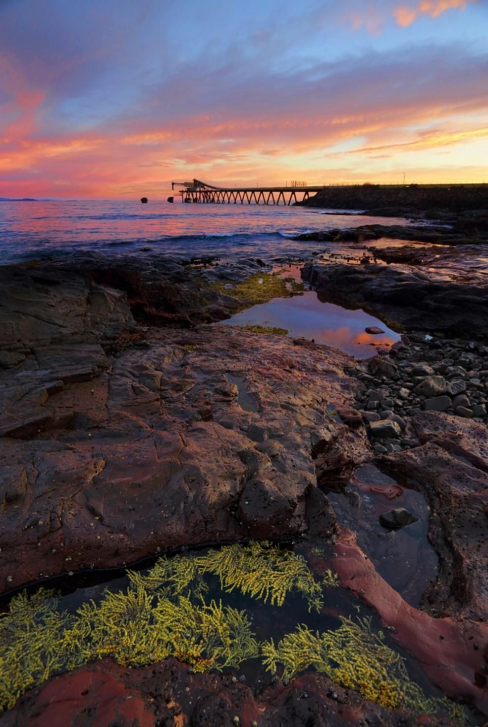Sunset Over Rocky Coast With Pier — JSF Interiors Goulburn in Shellharbour, NSW