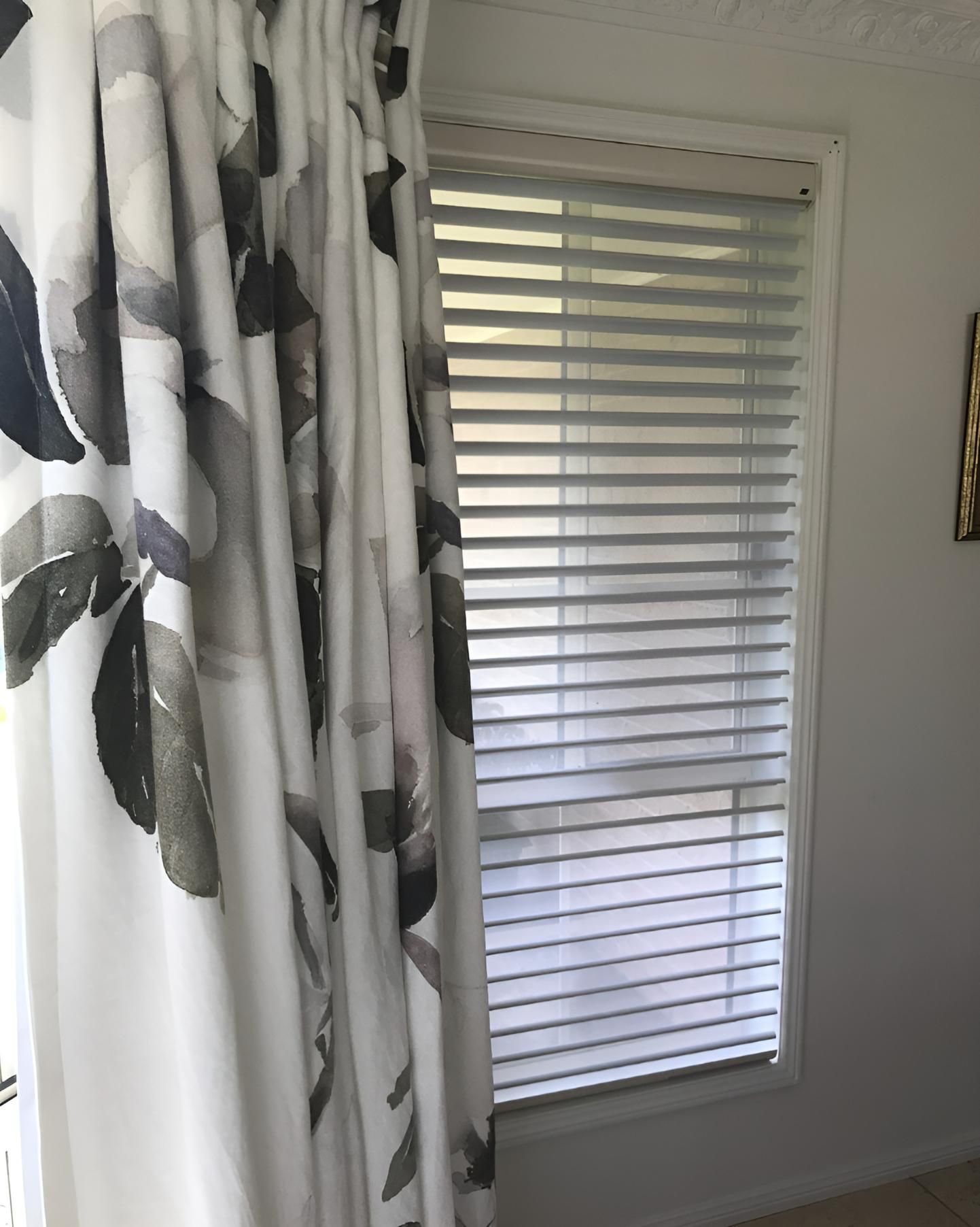 Window with Closed Blinds, Floral Curtain Partially Covering It, White Walls — JSF Interiors Goulburn in Moss Vale, NSW