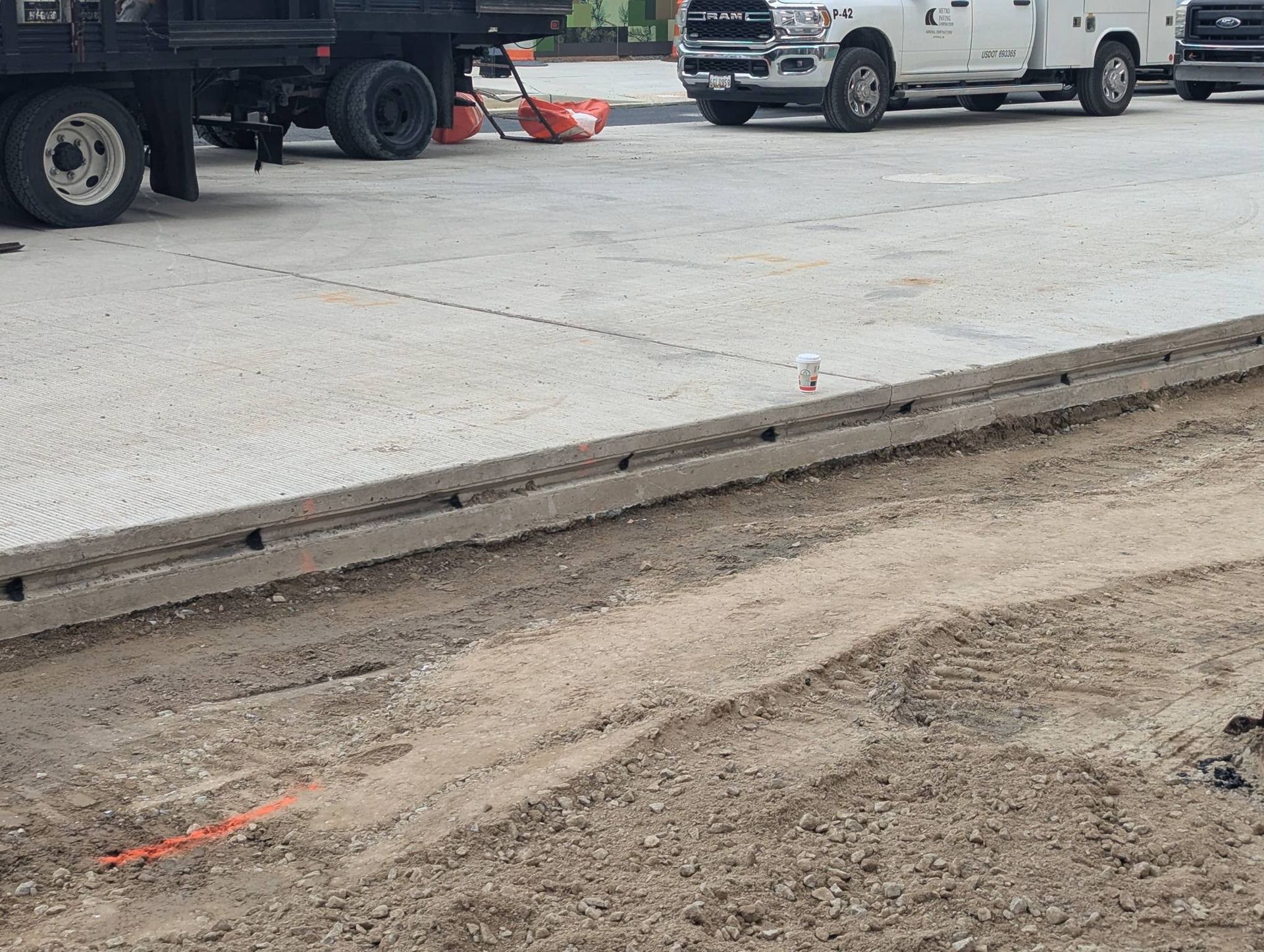 A black pool cover is sitting on top of a patio next to a swimming pool.