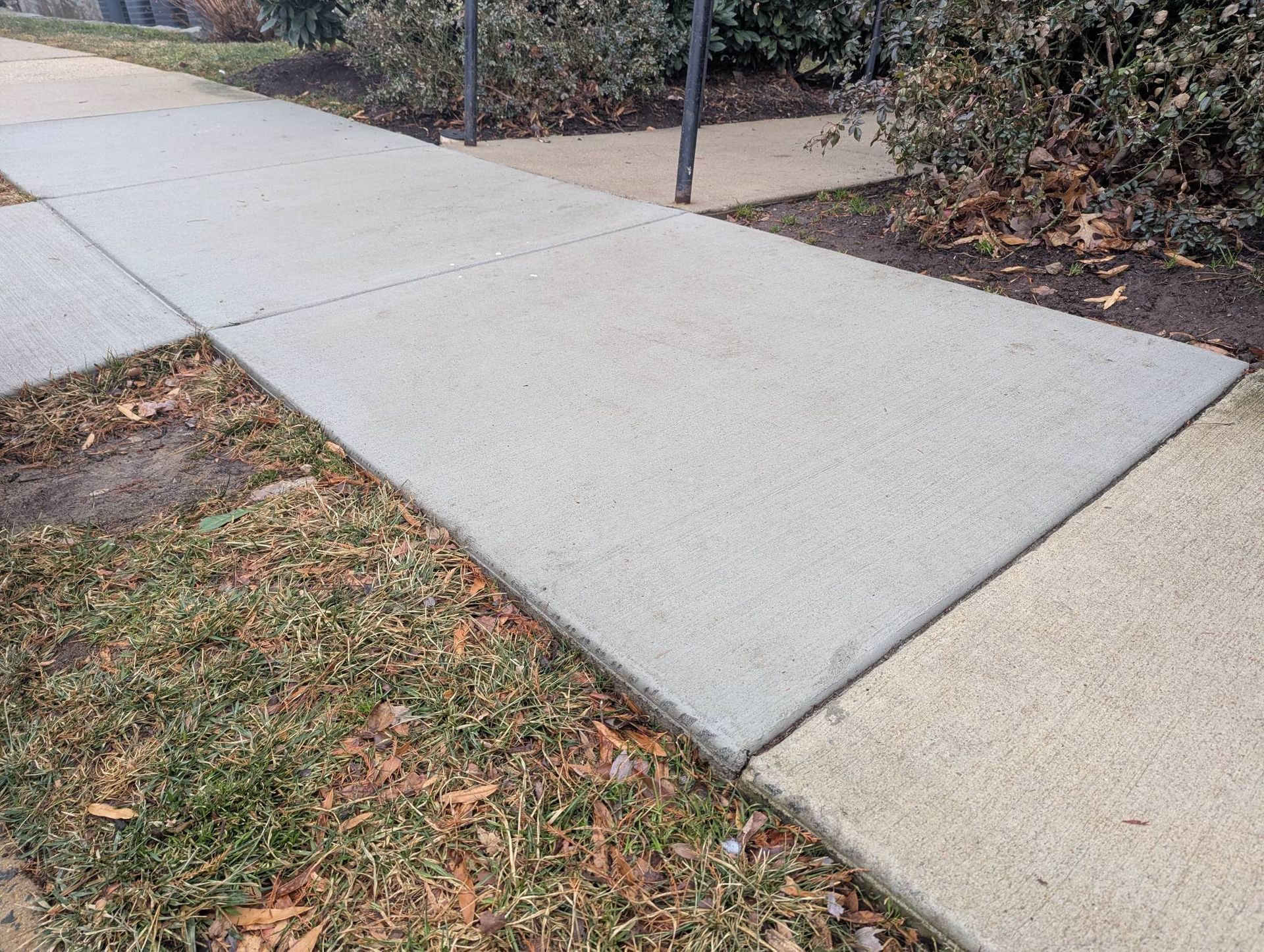 A walkway leading to a large building with a lot of windows.