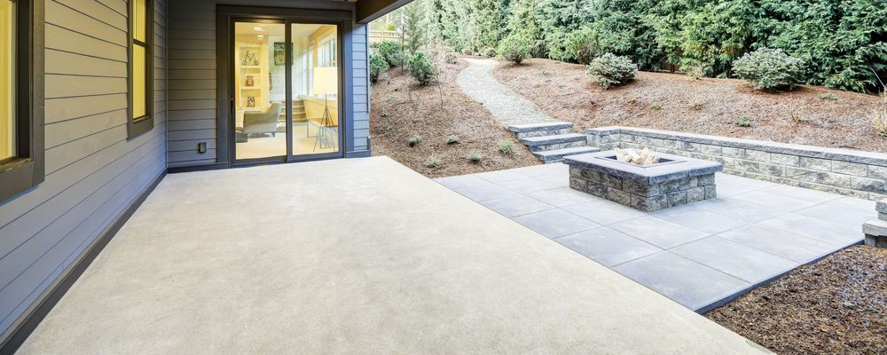 A concrete walkway in a park surrounded by green grass and trees.