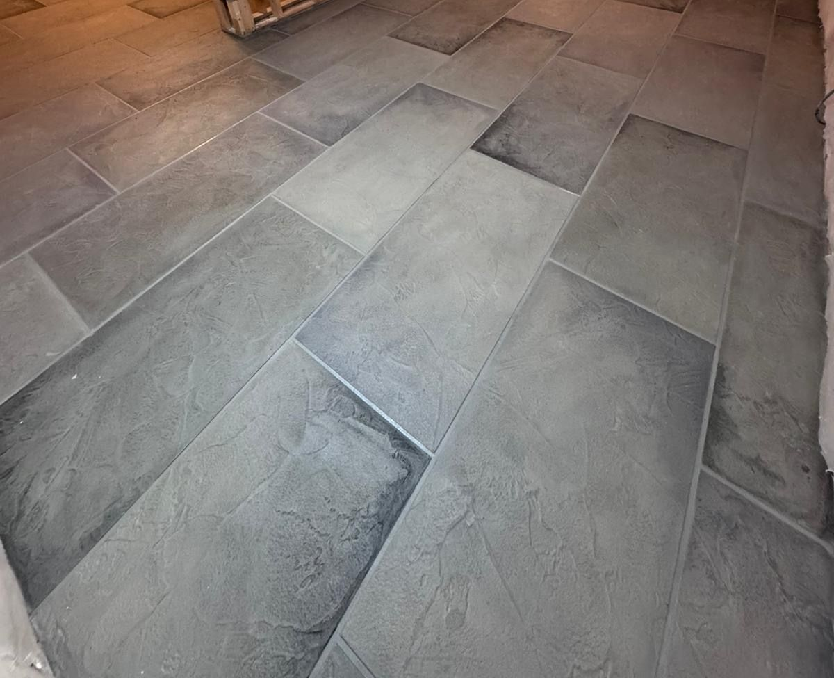 A concrete walkway in a park surrounded by green grass and trees.