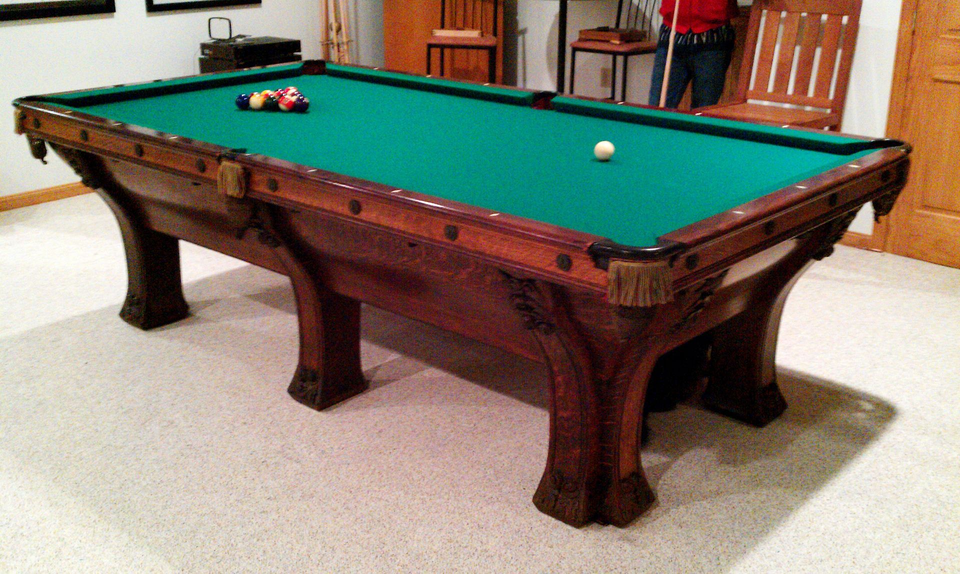 A pool table in a room with a ball on it