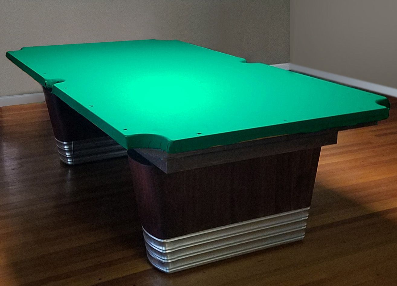 A pool table with a green cloth on it