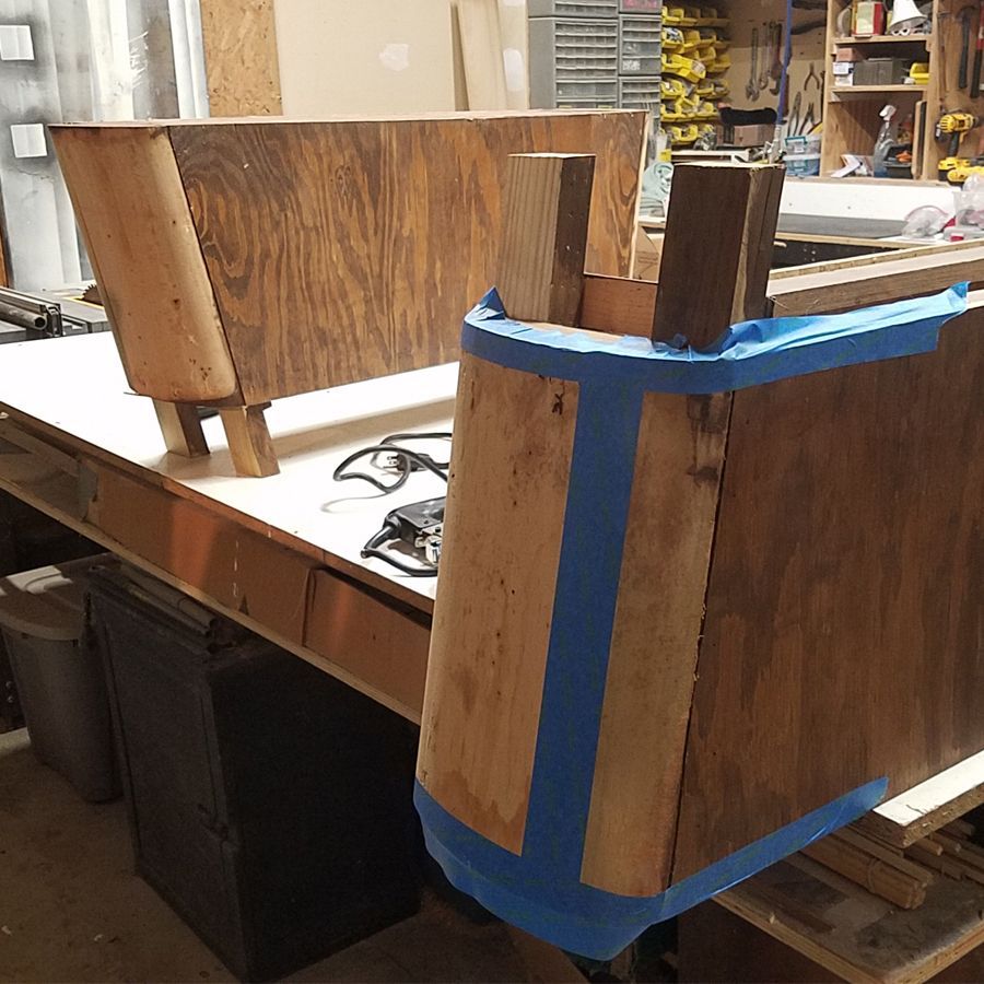 A piece of wood is taped to a table in a workshop