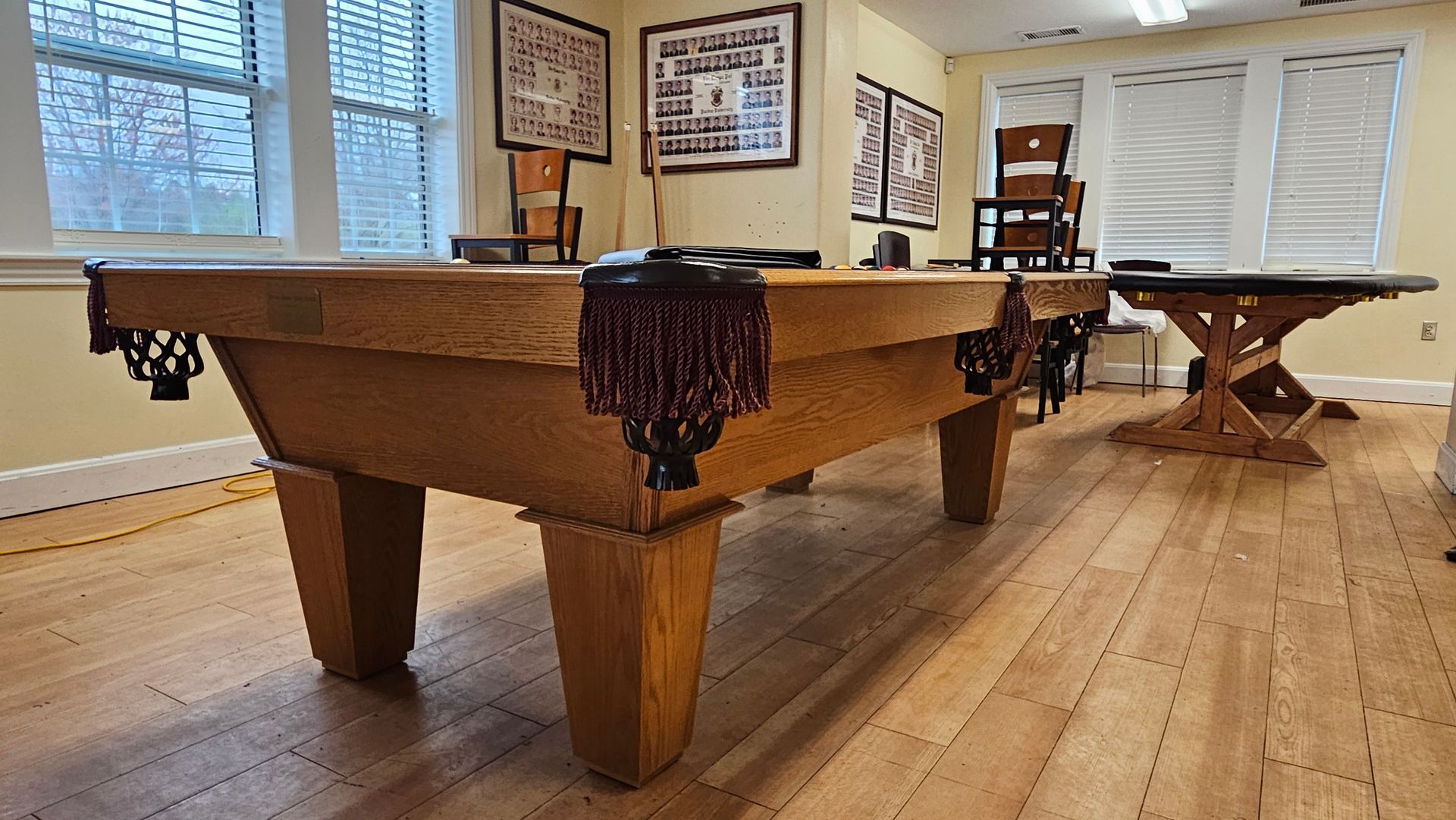 A pool table is sitting on a wooden floor in a room.