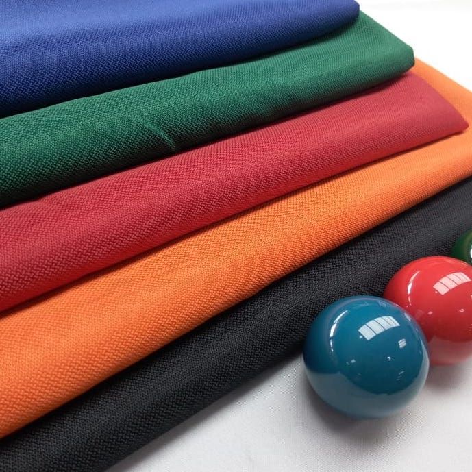 A stack of cloths and pool balls on a table