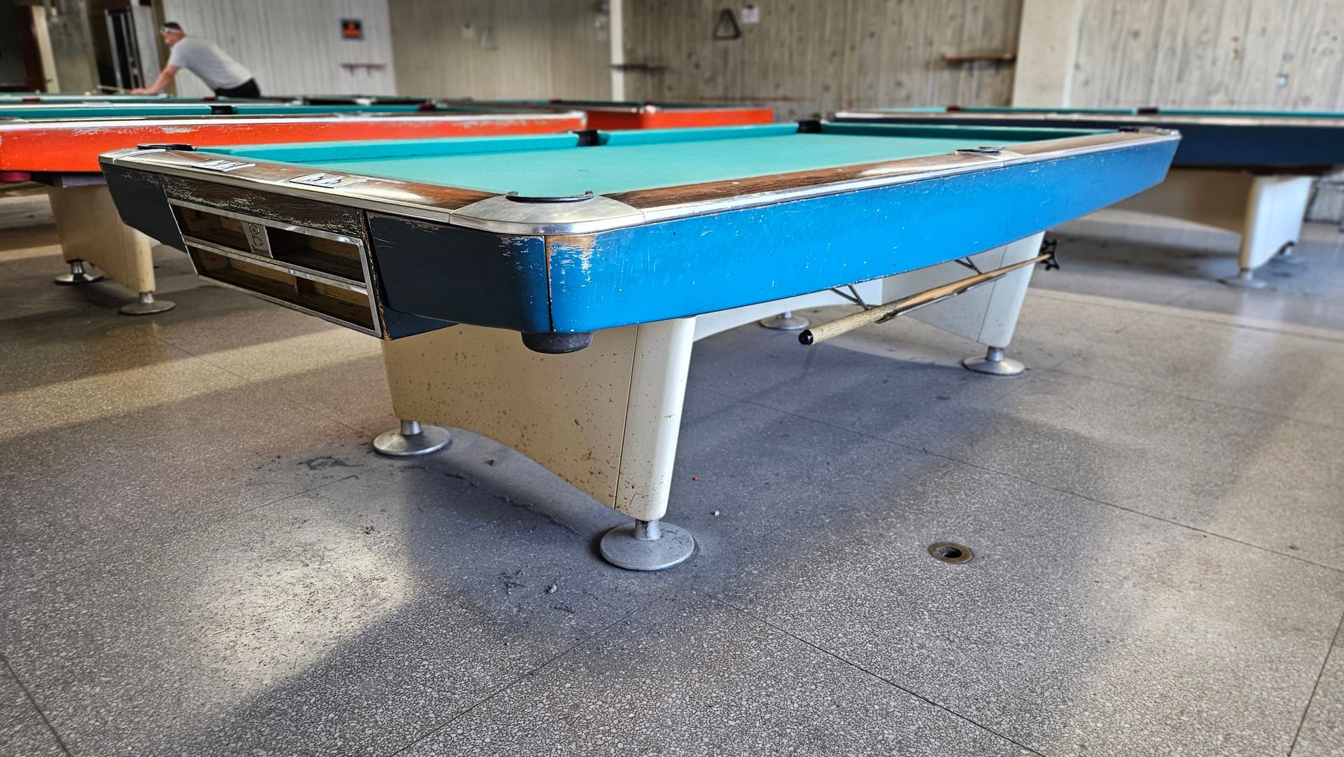 A pool table in a room with other pool tables