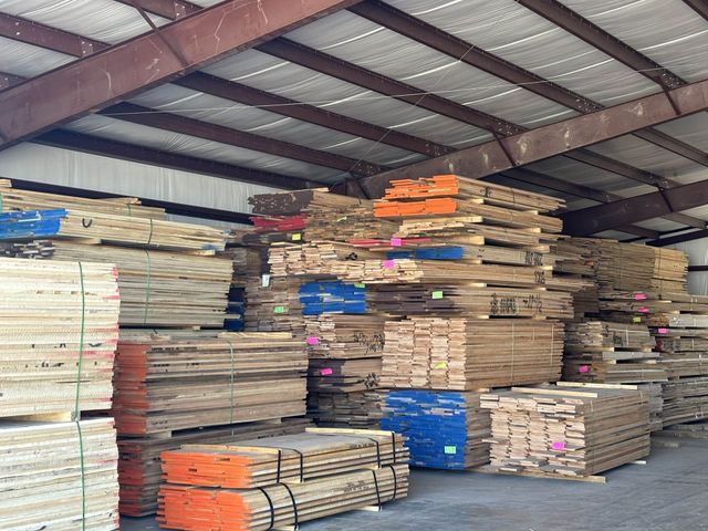 A warehouse filled with lots of wood stacked on top of each other
