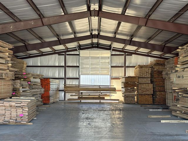 A large warehouse filled with lots of wooden pallets