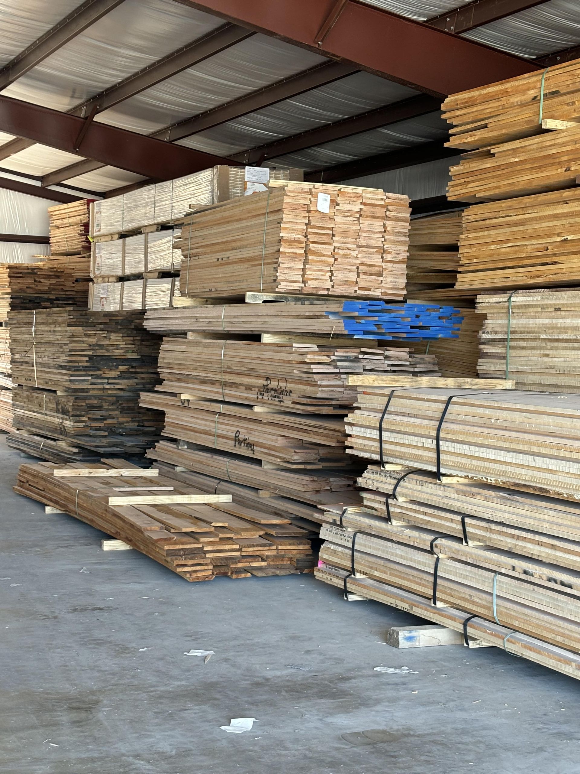 A warehouse filled with lots of wood stacked on top of each other.