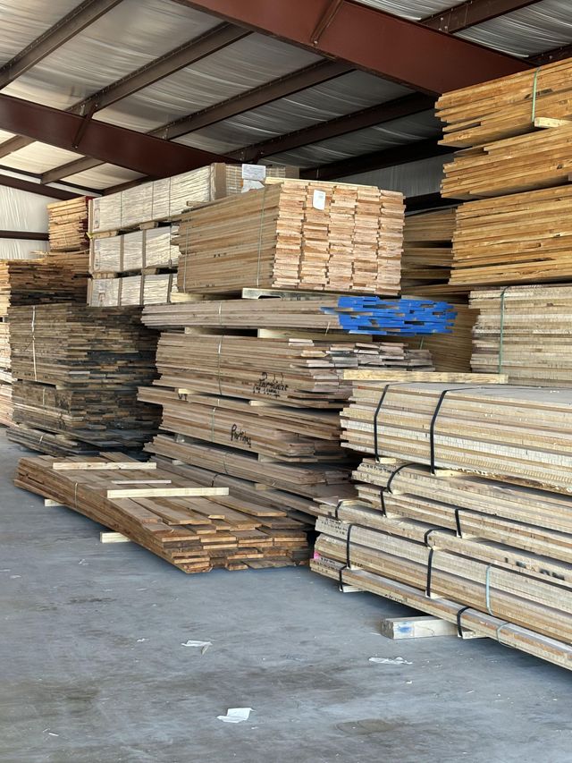 A warehouse filled with lots of wood stacked on top of each other.
