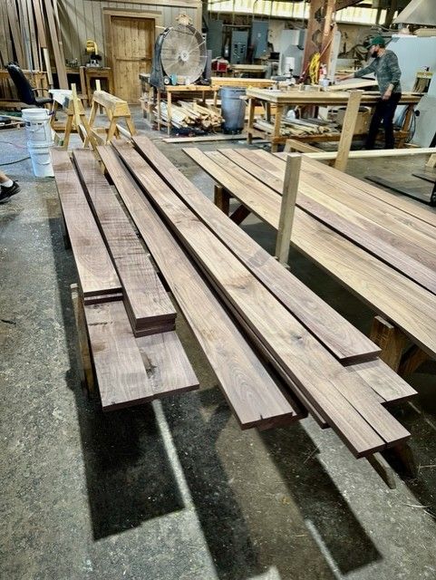 A bunch of wooden boards are stacked on top of each other in a workshop