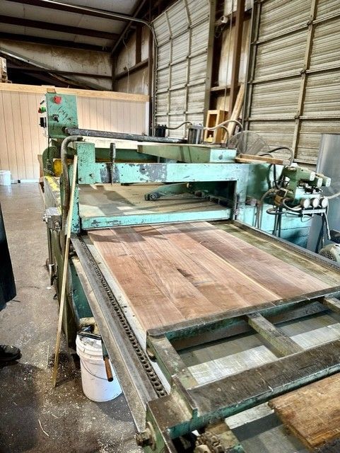 A machine is cutting a piece of wood in a warehouse.