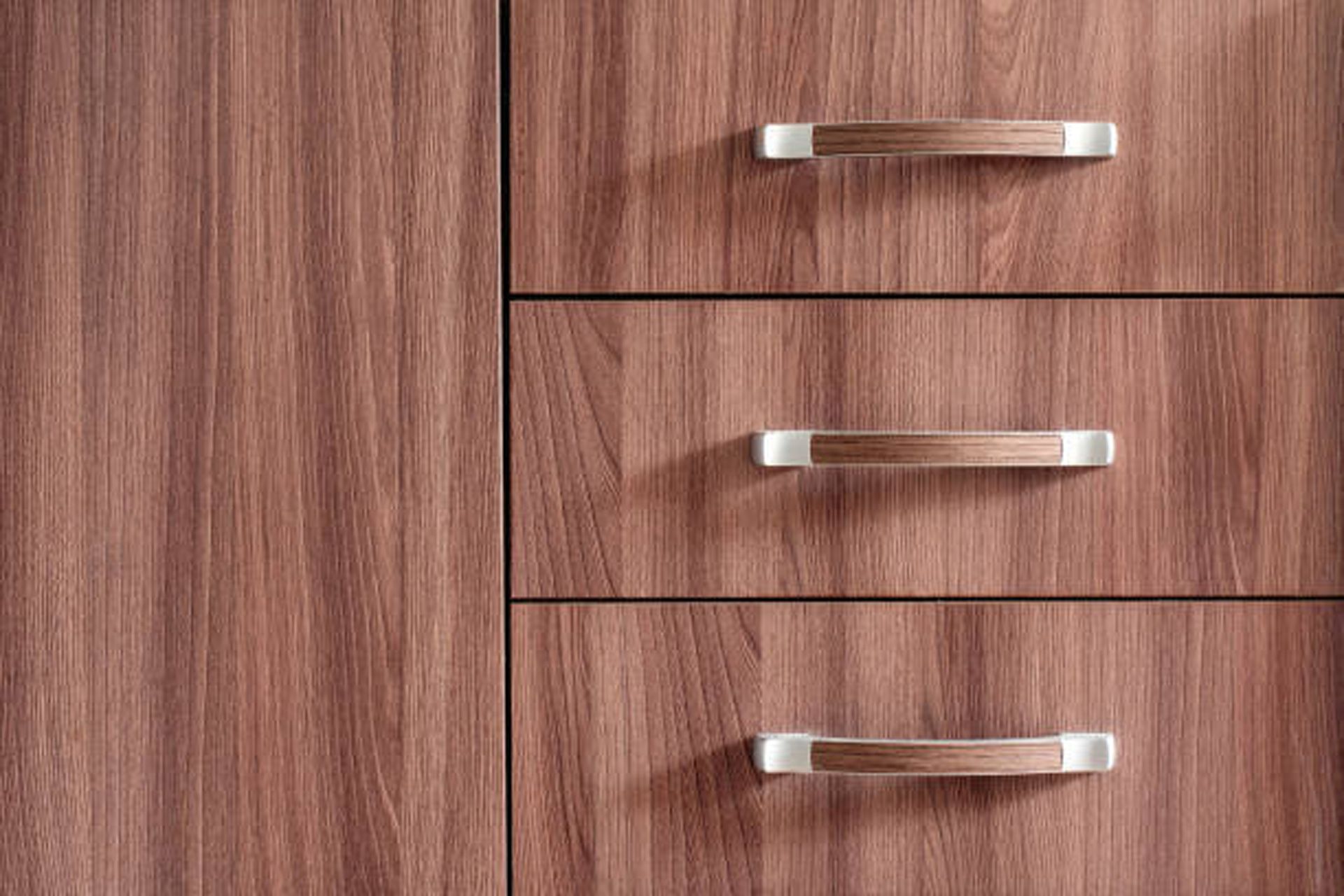 A close up of a wooden cabinet with three drawers and stainless steel handles.