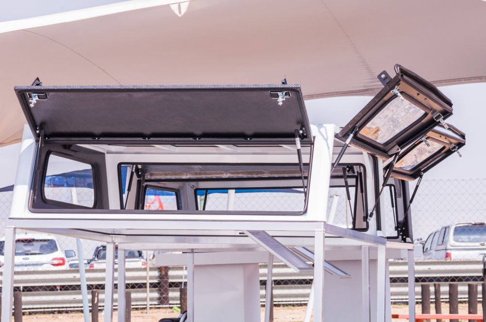 White truck bed camper shell with open side and roof panels on display. — Mid Coast Smash Repairs In Tuncurry, NSW