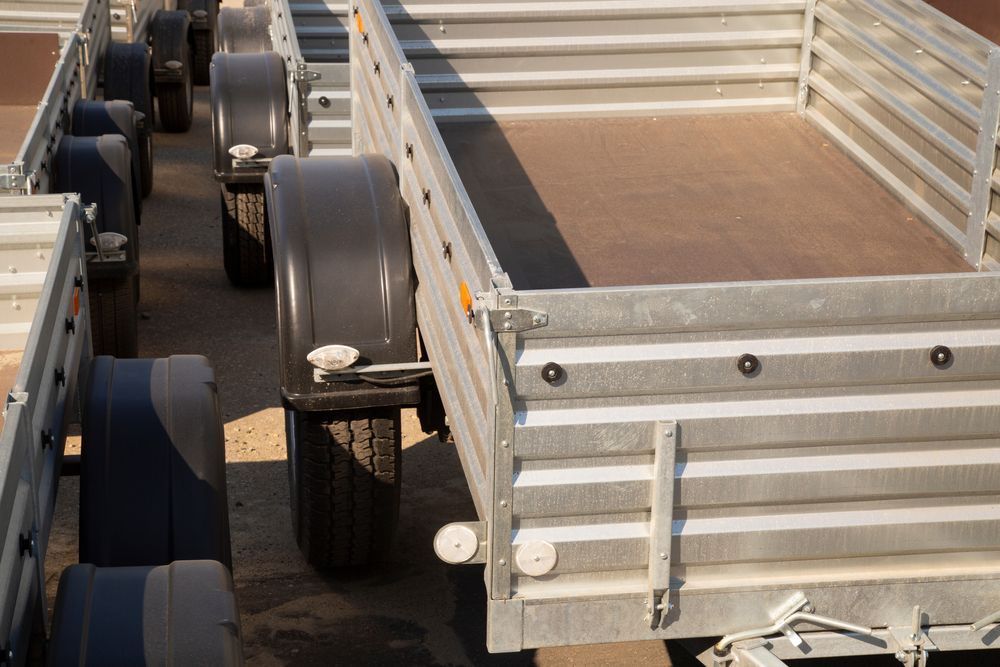 Trailers Parked in a Row, With Gray Metal Sides — Mid Coast Smash Repairs In Mid North Coast, NSW