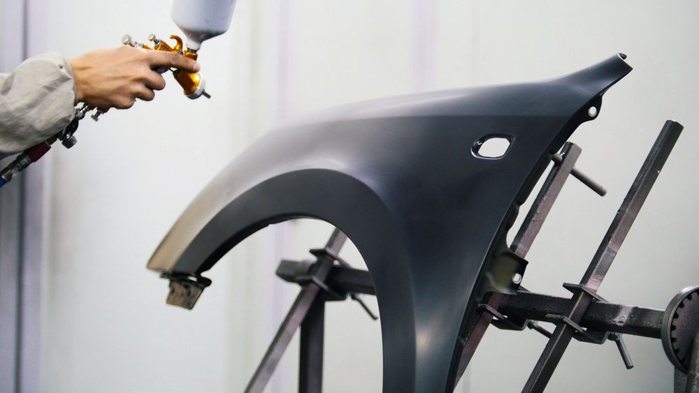 Car Fender Being Spray Painted With Gray Paint — Mid Coast Smash Repairs In Forster, NSW