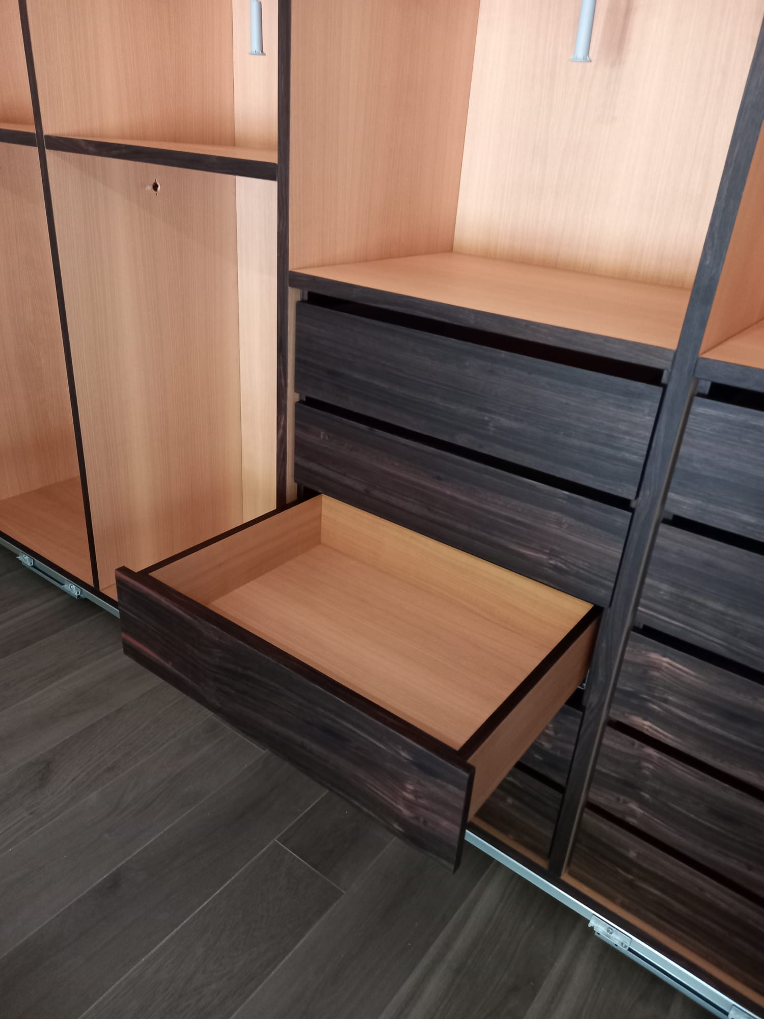 Organizer per armadio con cassetto in legno scuro parzialmente aperto, che mostra l'interno in legno chiaro.