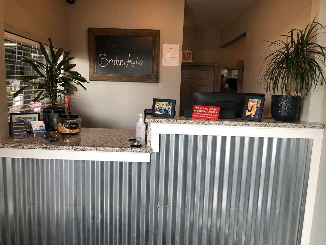 A reception desk in a restaurant with a chalkboard above it.