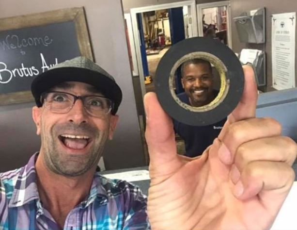 A man is holding a roll of black tape in his hand