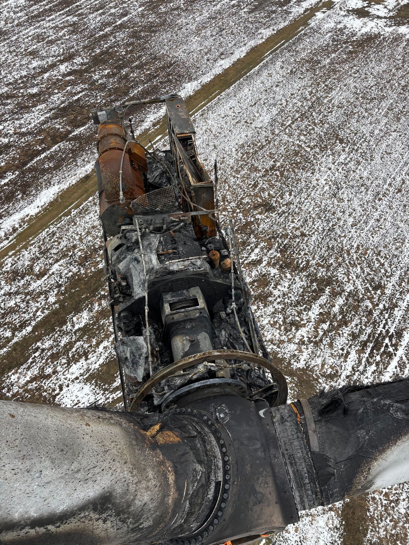 Een besneeuwd zonnepark met rijen panelen, windturbines en een bewolkte blauwe hemel.
