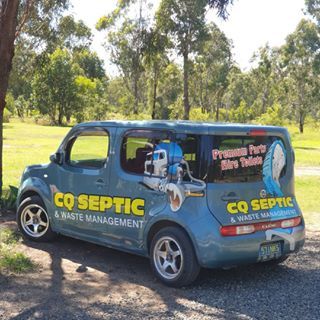 A septic and waste management van is parked in a grassy area