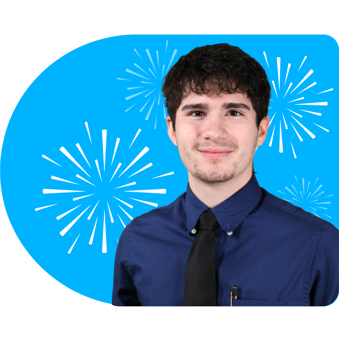 A person with blonde highlights, wearing a black blazer and necklace, posing against a blue background with white fireworks.