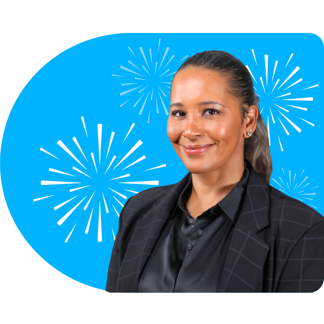 A person with blonde highlights, wearing a black blazer and necklace, posing against a blue background with white fireworks.