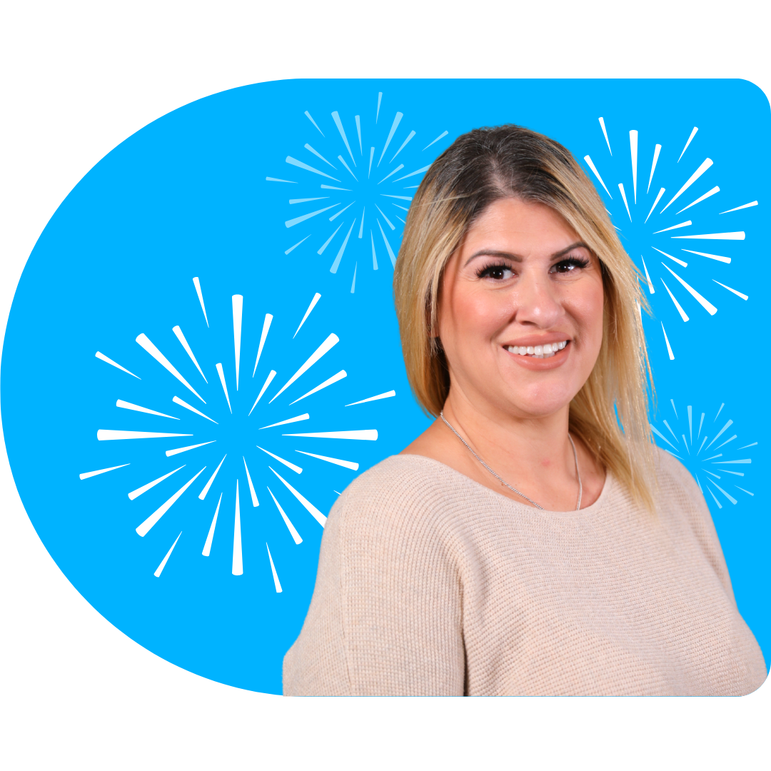 A person smiling, wearing a white blazer against a bright blue background featuring white, stylized firework illustrations.