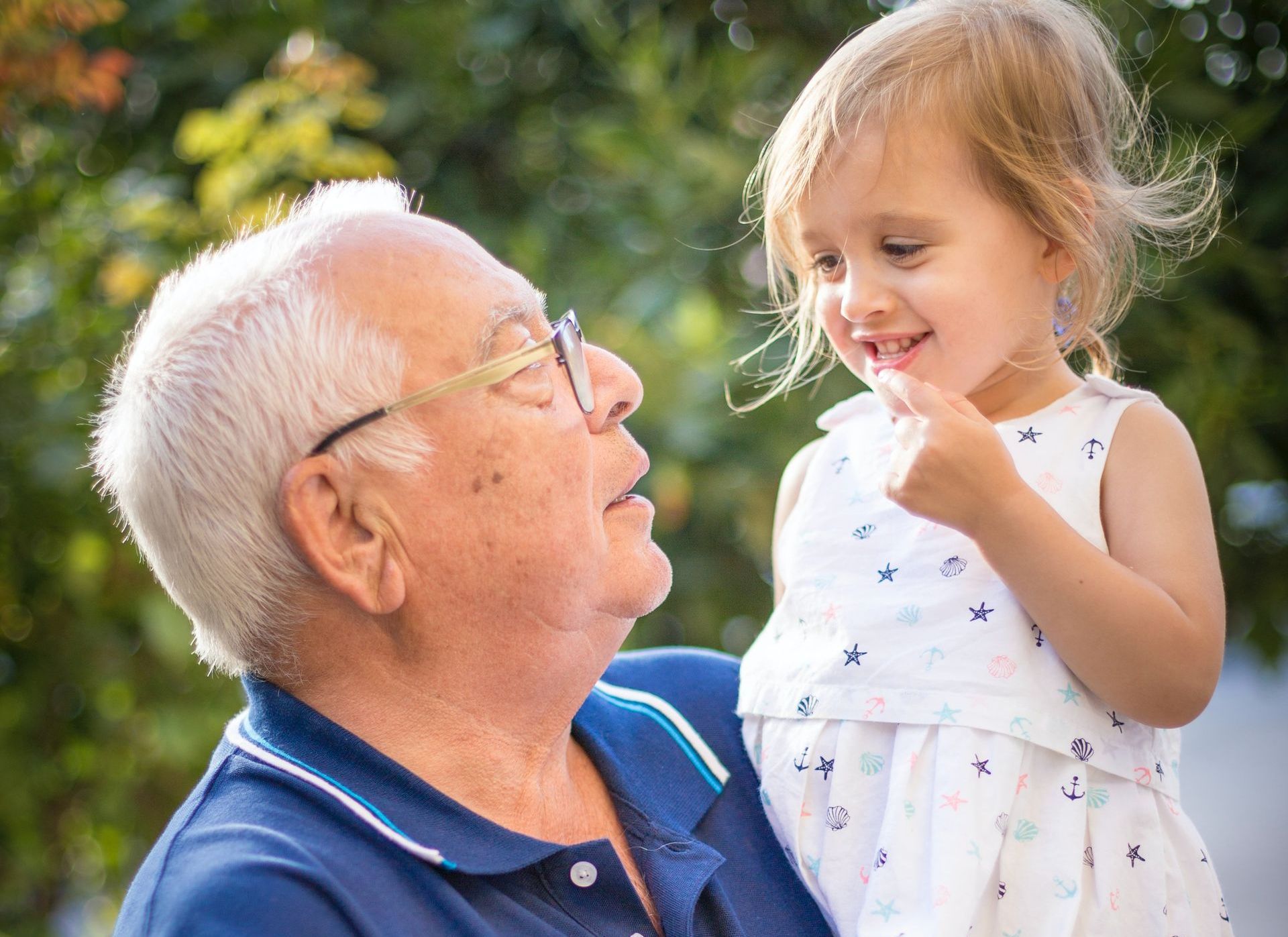 A man is holding a little girl in his arms.