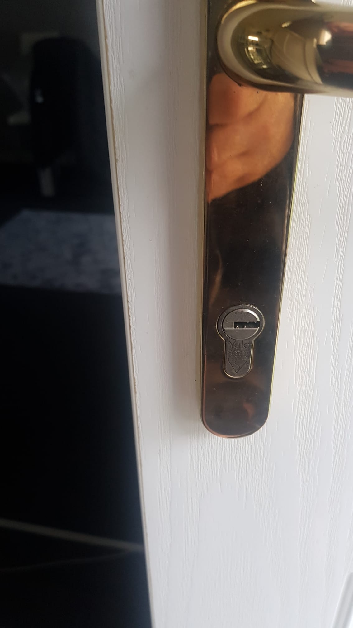 A close up of a door handle on a white door.