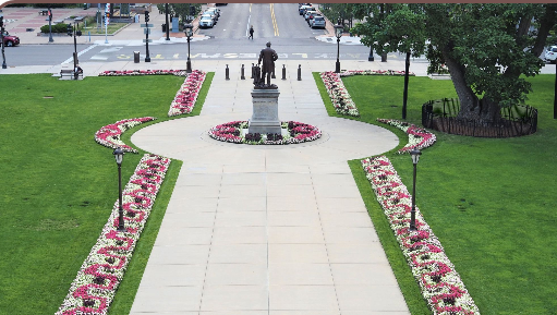 A statue of a man is in the middle of a park