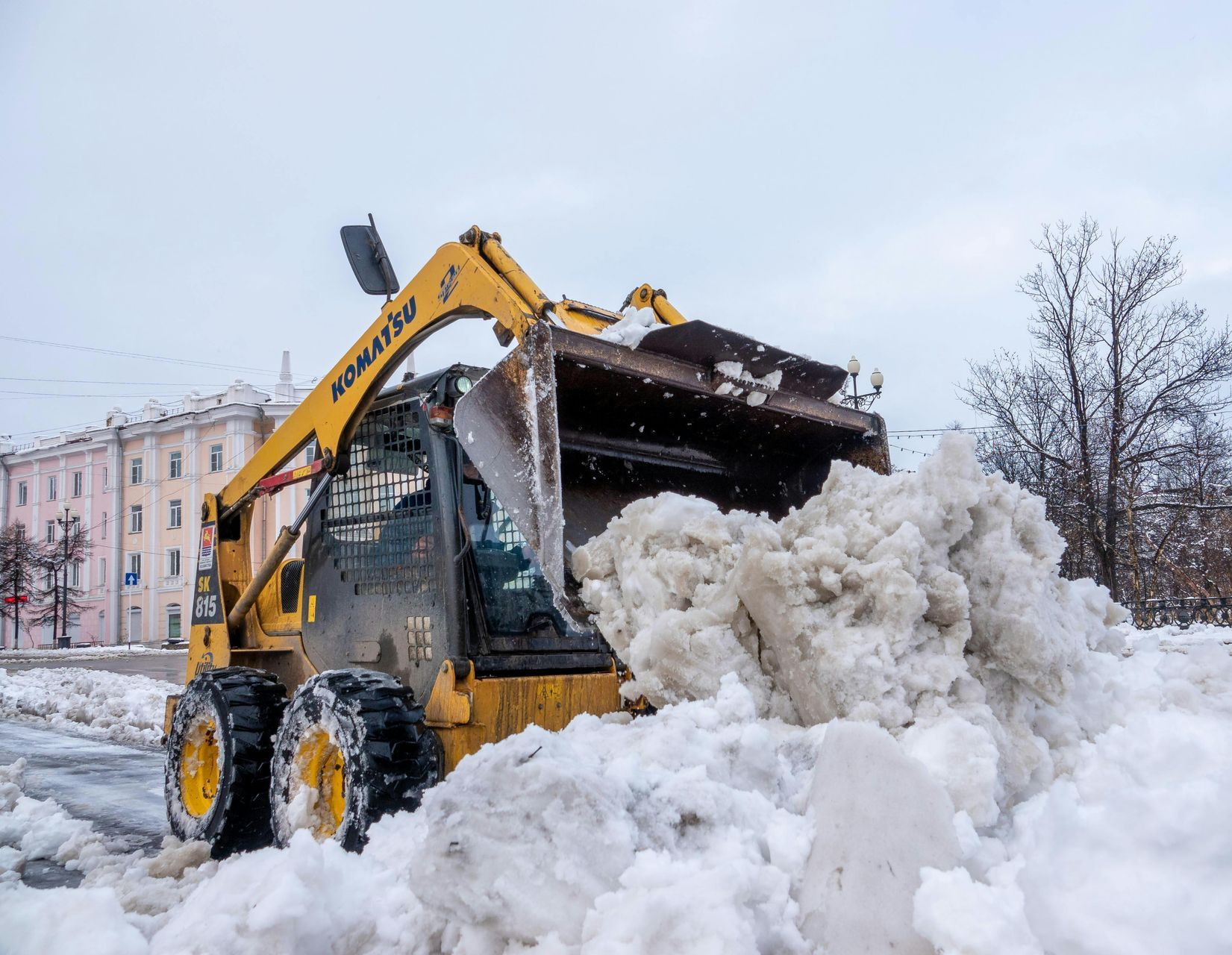 A yellow snow plow is clearing snow from a street.