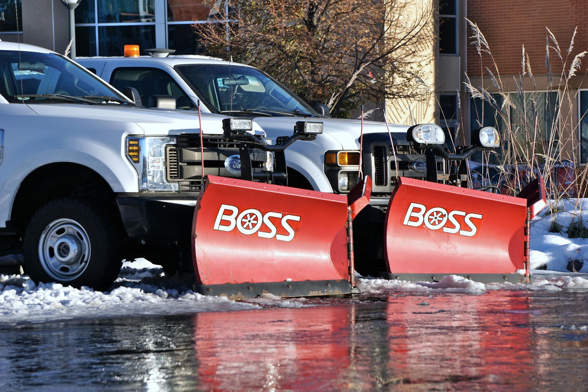 Two boss snow plows are parked next to each other