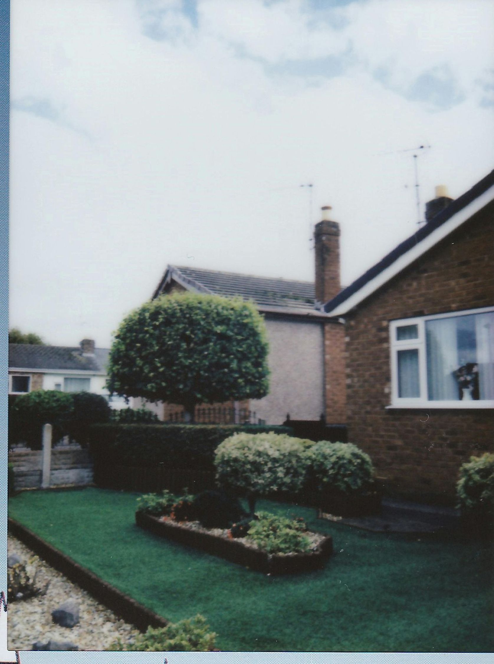 A picture of a house with a tree in front of it