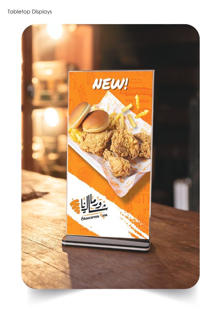 A sign that  is sitting on a wooden table.