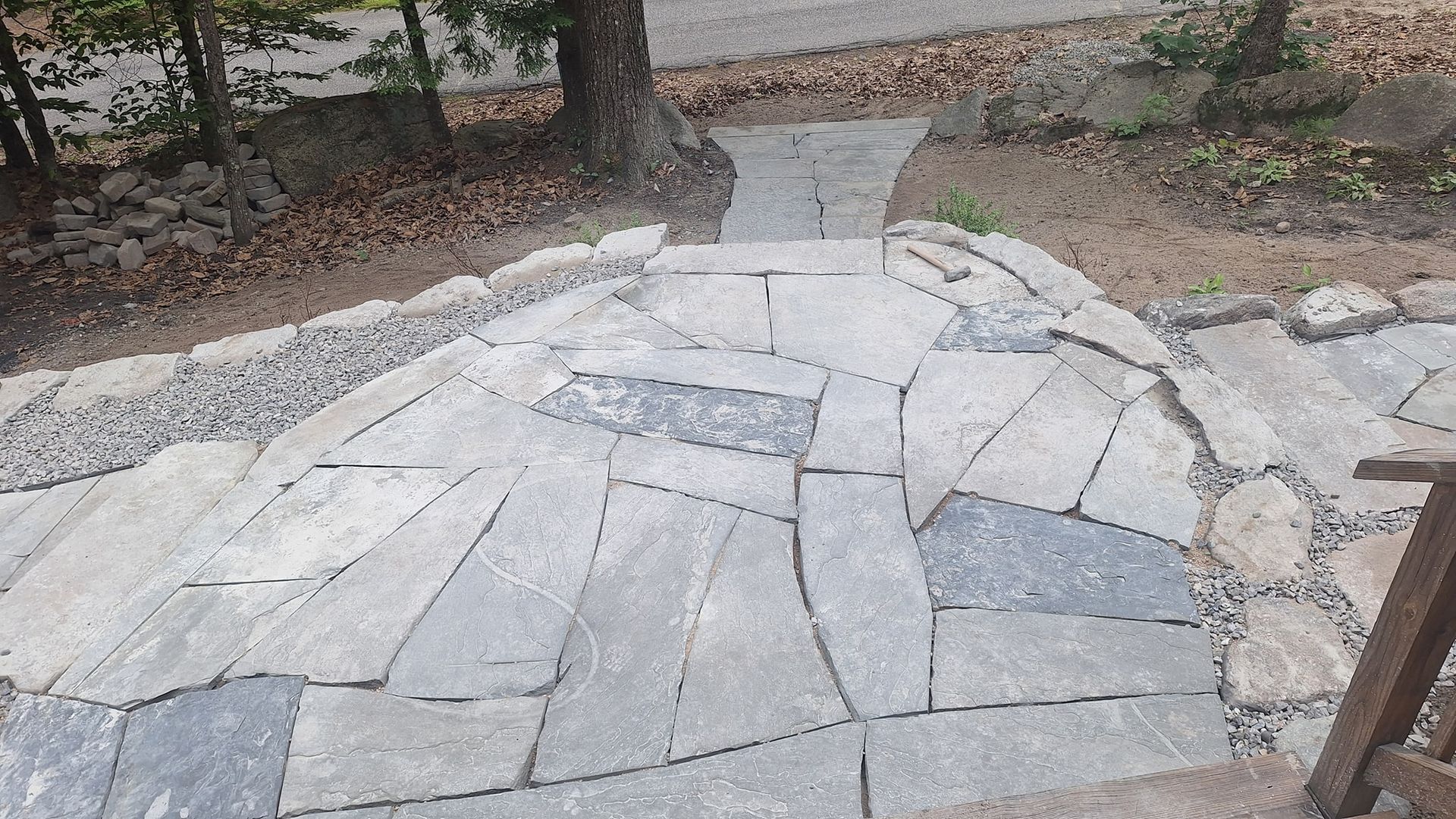 Stone path leading up steps with a tree in the background.
